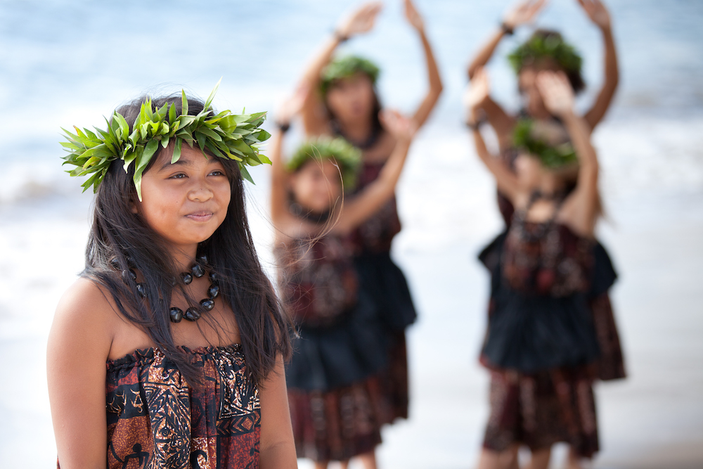 kids in traditional hula attire standing on beach in Hawaii