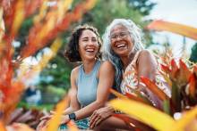 mother and daughter in Hawaii smiling outside surrounded by colorful background